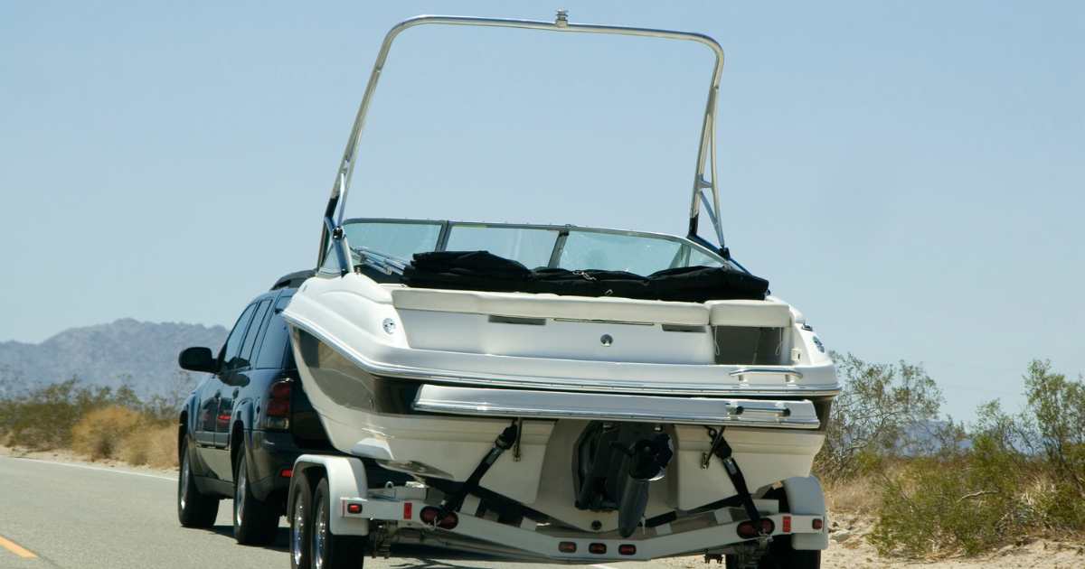 A boat being towed to a lake.