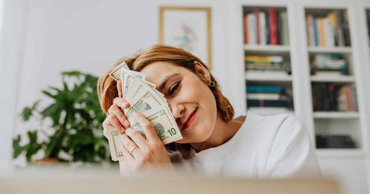 A woman holding her money after getting a loan.